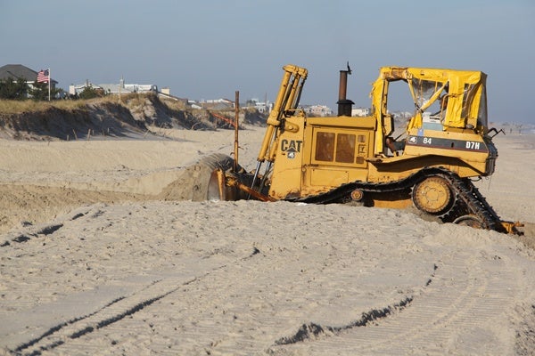 <p>A bulldozer on Long Beach Island moves sand to restore the dunes that were swept away by Hurricane Sandy. (Emma Lee/for NewsWorks)</p>

