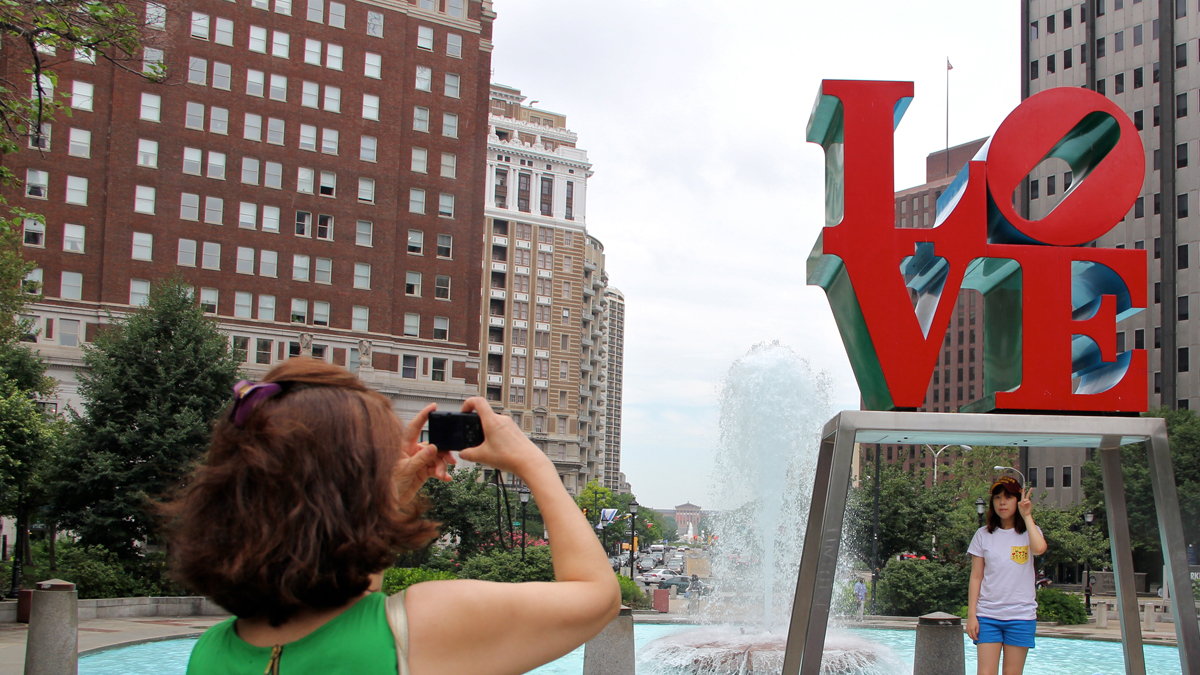  Tourists flock to Love Park in order to be photographed its iconic sculpture and fountain. (Emma Lee/WHYY) 