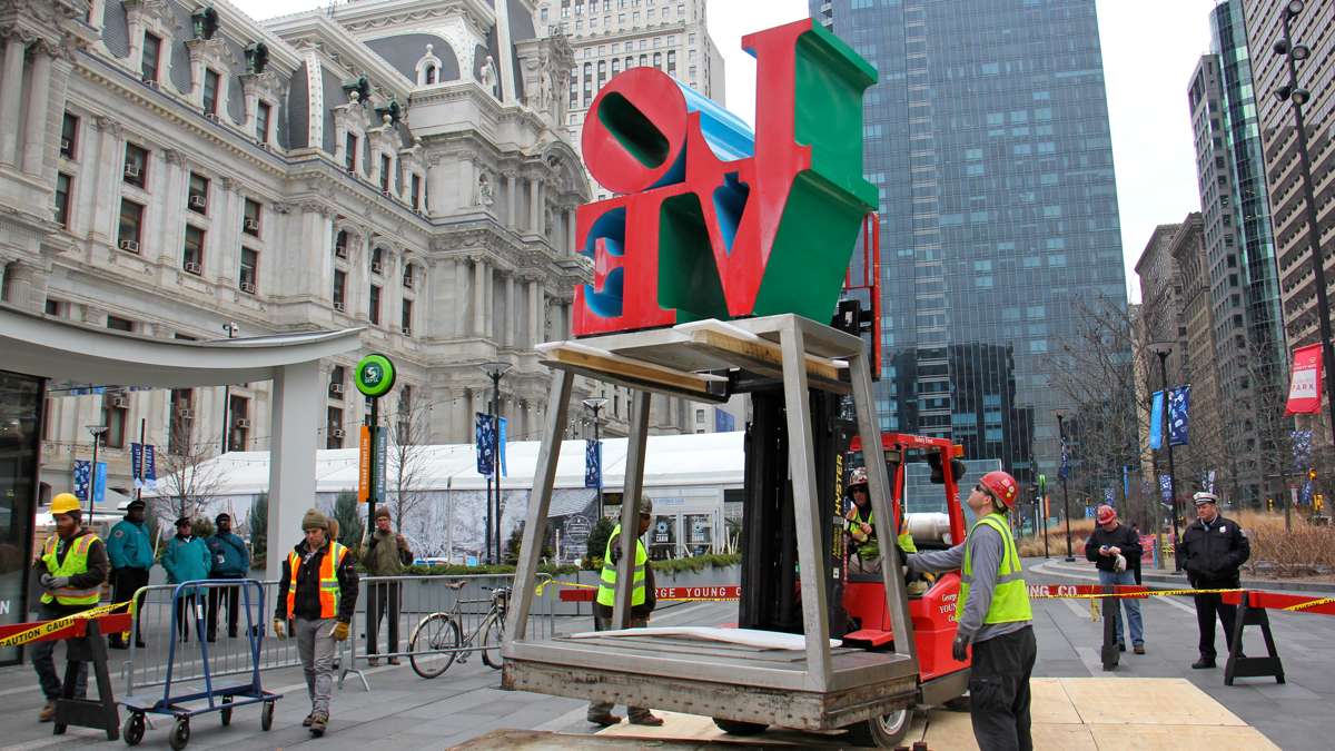 Workmen raise the LOVE sculpture off its pedestal in Dilworth Park.