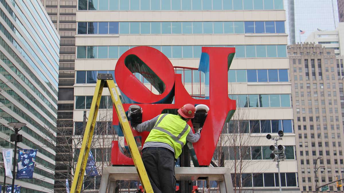 A workman guides the forklift that will disassemble the sculpture for transport.