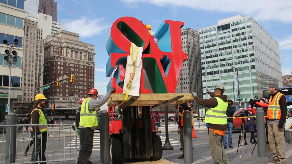 The sculpture is lifted over the barriers that protect Dilworth Park.
