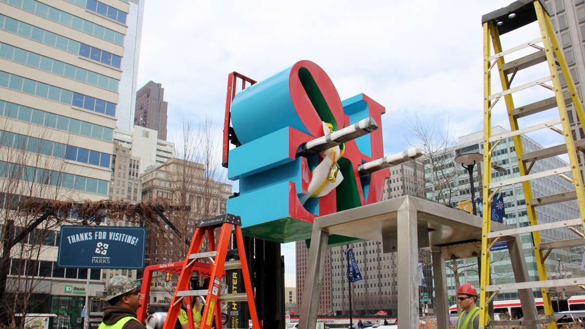 A forklift removes the top half of the LOVE sculpture.