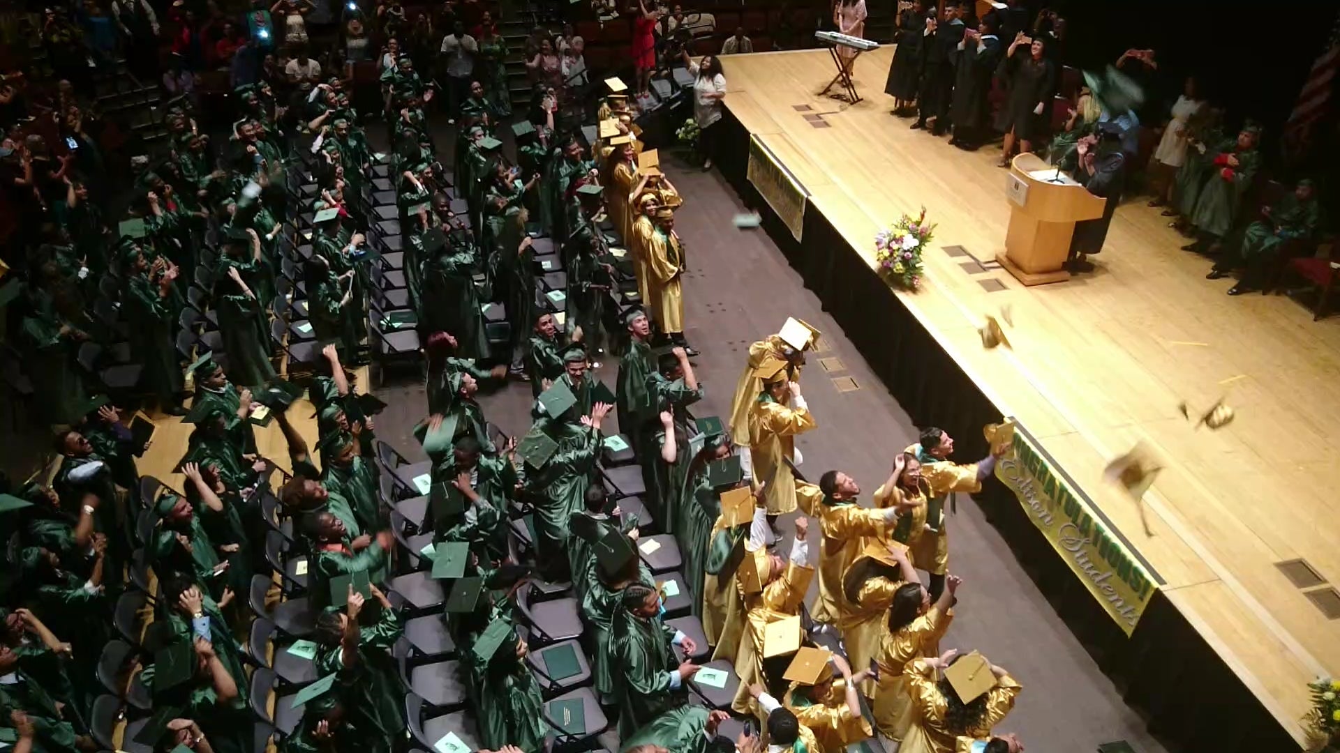 Edison students throw their caps in the air as their rite of passage is made official. Savannah (front row, middle) can be seen hugging a classmate. (Kevin McCorry/WHYY)