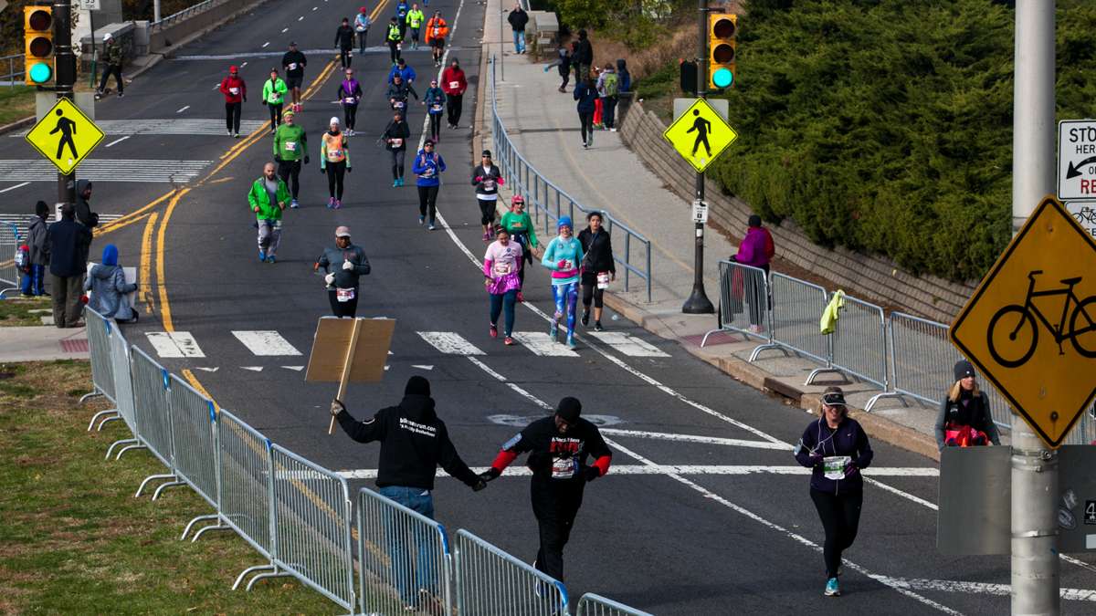 A runner gets a high five as he enters the final leg of the course during the Philadelphia Marathon.