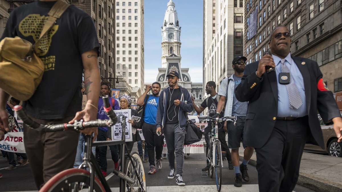 Police accompany protesters down South Broad Street near City Hall. (Branden Eastwood for NewsWorks