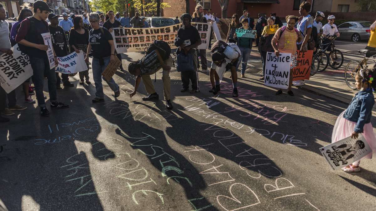 Protesters write slogans on the ground in chalk on South Street.