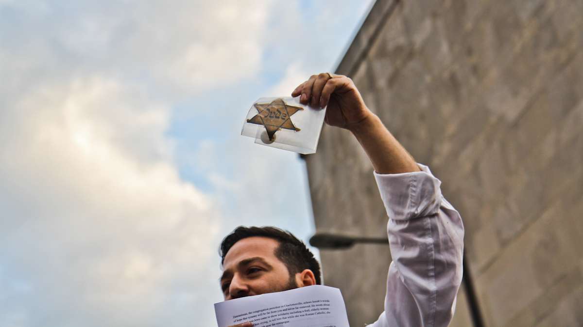 Rabbi Eli Freedman of Congregation Rodeph Shalom holds up a Star of David worn by a holocaust survivor at the Philly is Charlottesville march Wednesday evening. (Kimberly Paynter/WHYY)