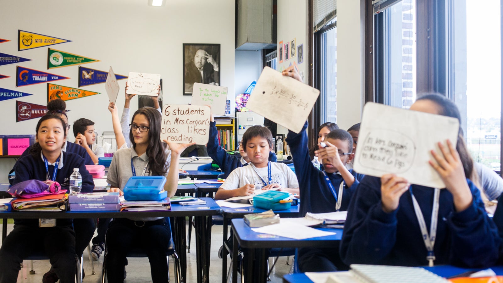  Seventh grade students at Mastery Charter School's Thomas Campus hold up answers to pre-algebra word problems. (Brad Larrison for NewsWorks) 