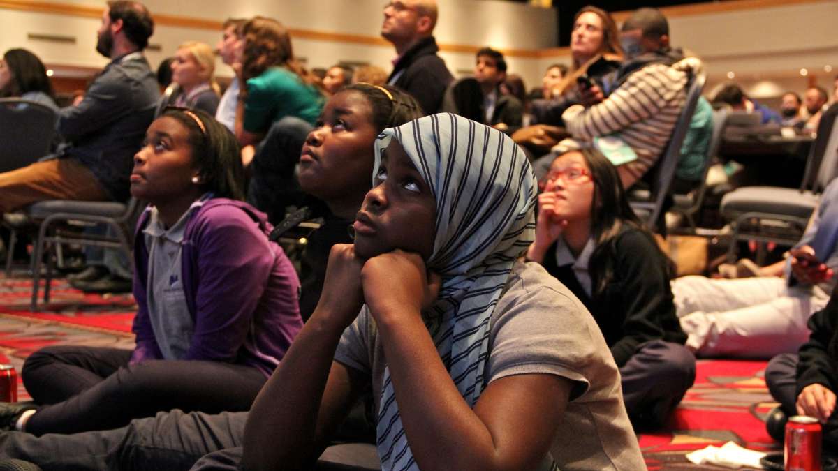 Children find seats on the floor of the crowded ballroom at the Pennsylvania Convention Center to see Malala Yousafzai. (Emma Lee/WHYY)