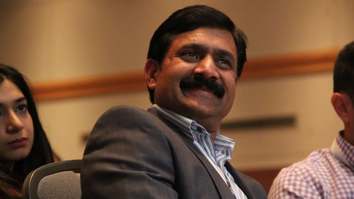 Ziauddin Yousafzai smiles as his daughter, Malala tells stories about her brothers during an appearance at the Forbes Under 30 Summit. (Emma Lee/WHYY)