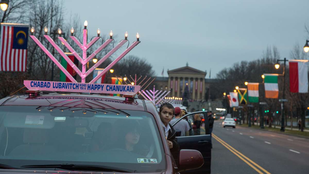 More than 250 cars gather on the Ben Franklin Parkway to parade through the city with lit electric menorahs atop their roofs in celebration of the third night of Hanukkah.