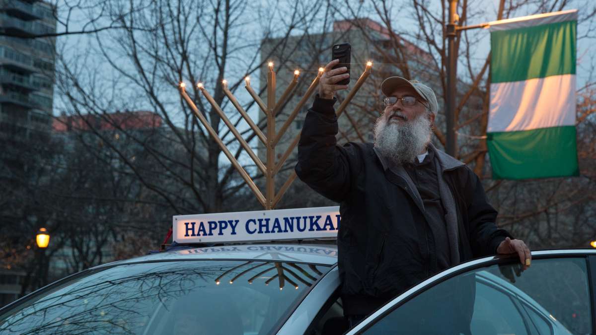 A driver captures the spectacle of 250 cars adorned with lit electric menorahs as they line up for the 10th Annual Car Menorah Parade put on by Rabbi Abraham Shemtov, the regional director of Chabad Lubavitch, an Orthodox Jewish movement.