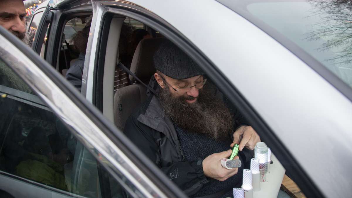 Arthur Sauerhaft, from Chester, Pennsylvania, puts batteries into his car menorah in preparation for the 10th Annual Car Menorah Parade in Philadelphia.