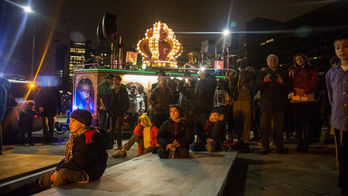 Children and adults gather under the massive menorah on Independence Mall as Rabbi Abraham Shemtov, the regional director of Chabad Lubavitch, says the blessings and lights the candles for the third night of Hanukkah December 26, 2016.