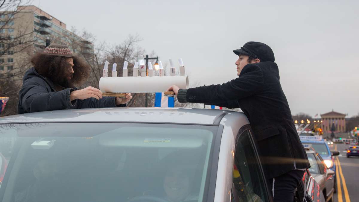 Benjamin and Amiati Coplon secure their car menorah in preperation for the 10th Annual Car Menorah Parade in Philadelphia on December 26, 2016.