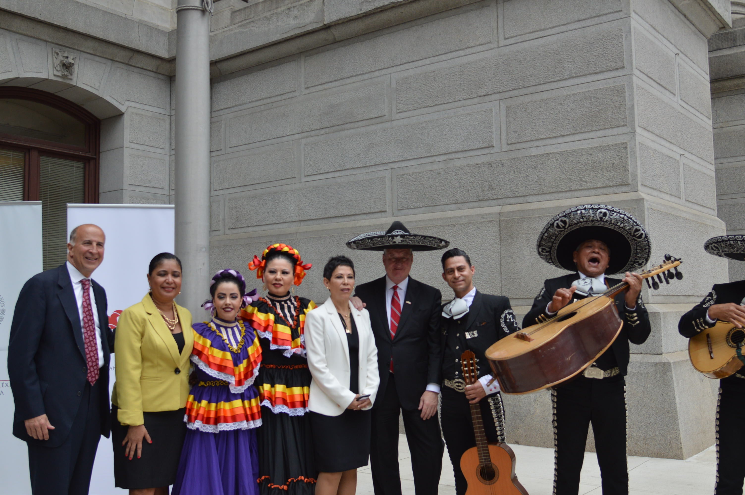  A sombrero-wearing Mayor Jim Kenney (third from right) and Alicia Kerber-Palma, Mexico's consulate general Alicia Kerber-Palma (fourth from right) take part in Mexican flag-raising ceremonies at Philadelphia City Hall. (Tom MacDonald/WHYY) 