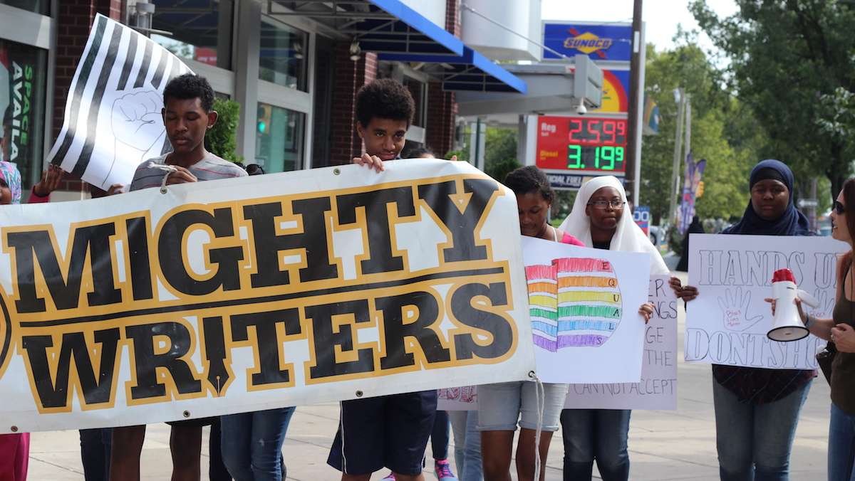 Ten students from Mighty Writers South marched down South Broad Street to City Hall with a banner and posters discussing LGBTQ issues, mass incarceration, police brutality and drug laws. (Emily Scott / WHYY)