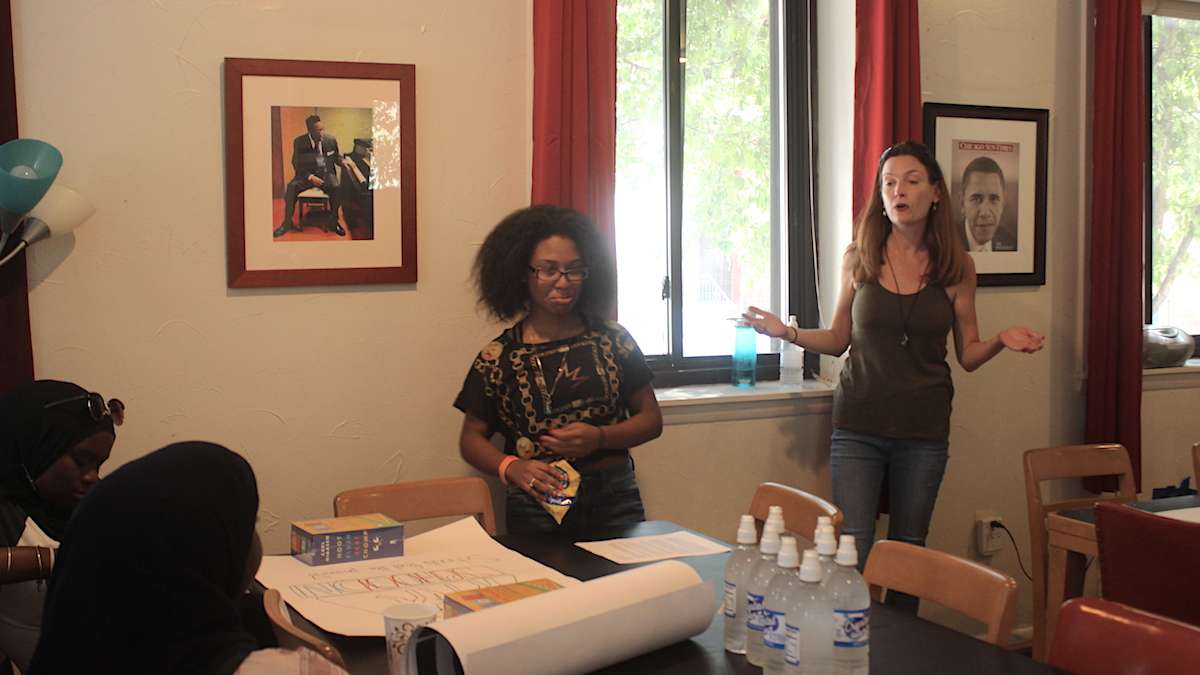 Peggy Kern (right) speaks with Mighty Writers South students prior to their march toward City Hall. (Emily Scott / WHYY)