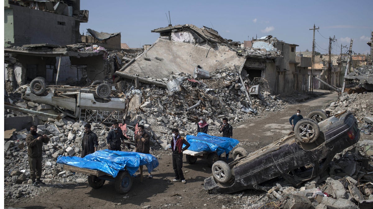  Residents carry the bodies of several people killed during fights between Iraq security forces and Islamic State on the western side of Mosul, Iraq, on Friday, March 24, 2017. (AP Photo/Felipe Dana) 