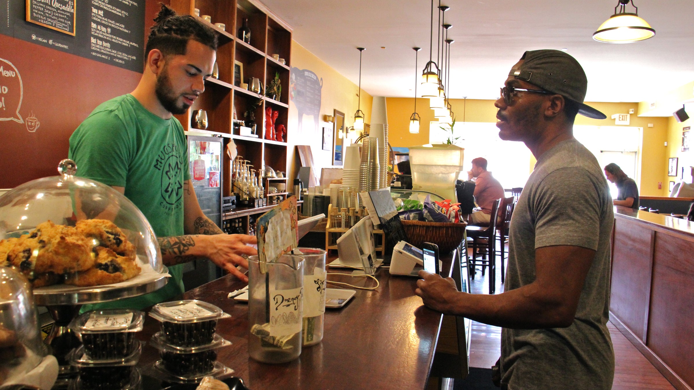  José Laboy (left) takes a customer's order at Mugshots café on Fairmount Avenue. (Emma Lee/WHYY) 