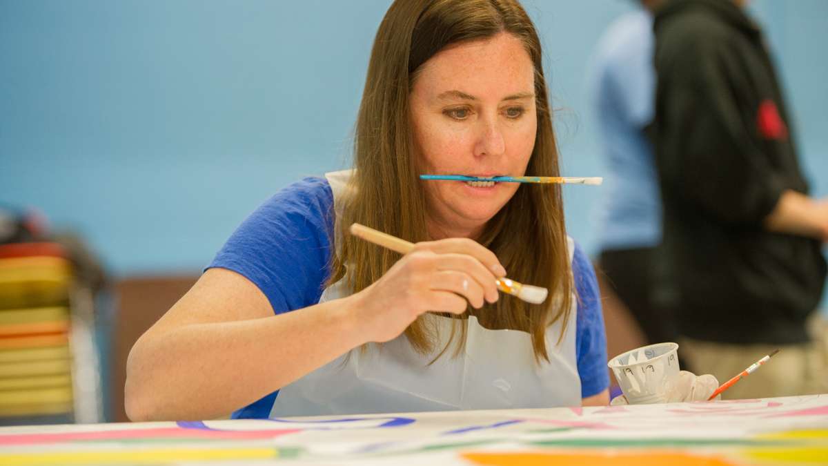 Meg Dath puts some finishing touches on a nearly completed mural square.