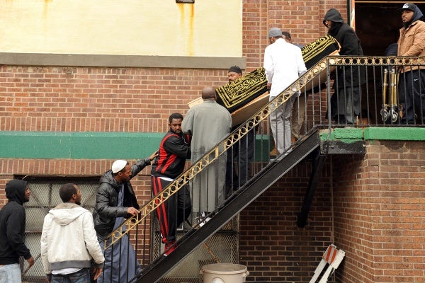 <p><p>The casket is brought down the steps of the mosque by friends and relatives. (Peter Tobia/for NewsWorks)</p></p>
