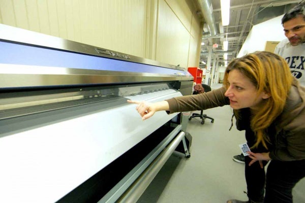 <p><p>The Roland XR-640 Vinyl Print/Cut System 64" is printing vinyl stickers for the upcoming event. Rachel Kotkoskie, facility coordinator at NextFab and photographer, is pointing out the blade on the printer head as it prints. (Nat Hamilton/for NewsWorks)</p></p>
