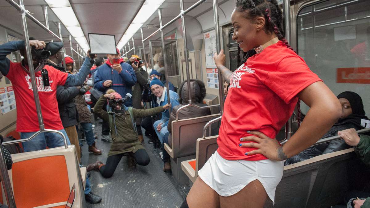 Kenji Butler poses for photos as the Broad Street Subway heads south.