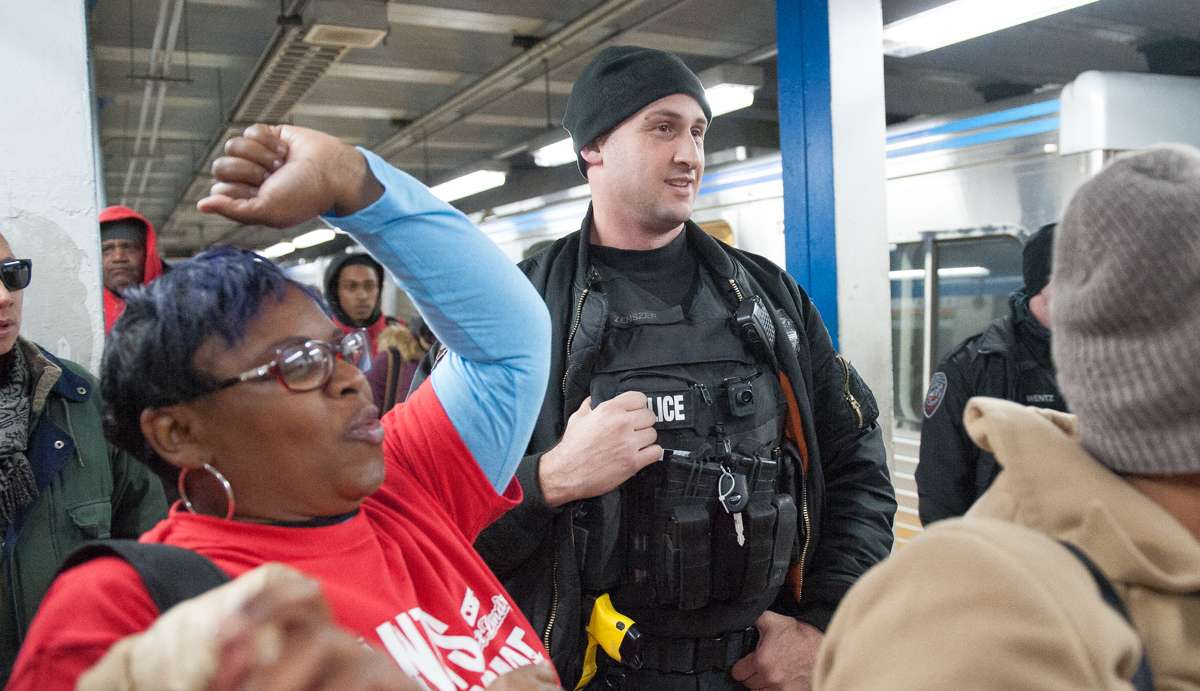 An amused SEPTA Police Officer watches the No Pants participants on the Market-Frankford Line platform.