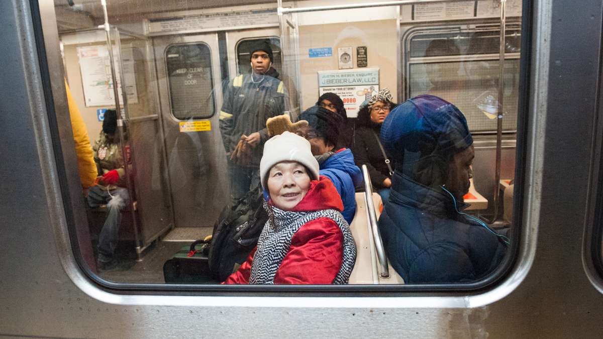 Riders watch the No Pants Subway Riders on the City Hall subway platform.