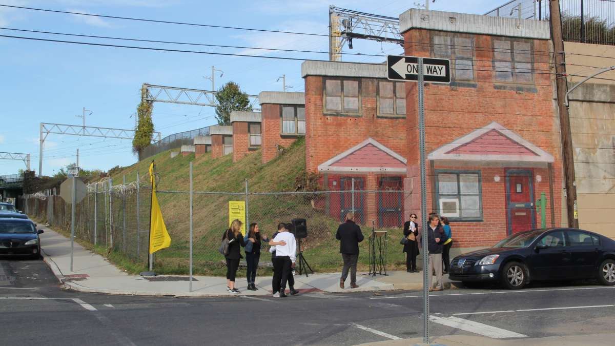 Painted on the buttresses of a railroad embankment, the mural will memorialize the Norris Homes housing project, slated to be razed and rebuilt. (Emma Lee/WHYY)