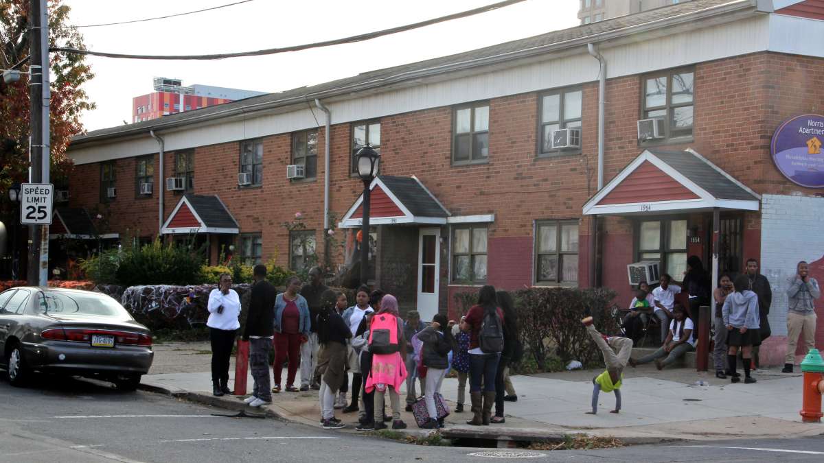 Norris Homes residents gather on the corner of 10th and Norris streets for the dedication of Norris Homes Historical Marker, a mural by Jennie Shanker. (Emma Lee/WHYY)