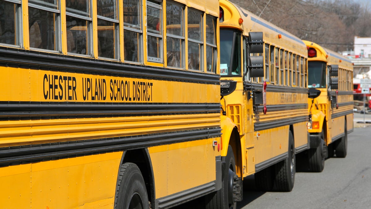Buses from Chester Upland School District await dismissal from Chester High School on West Ninth Street. (Emma Lee/WHYY) 