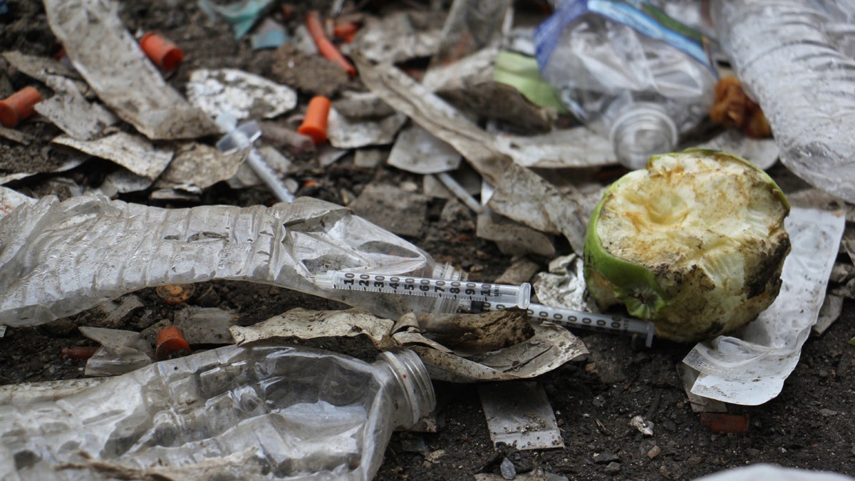 Thousands of used needles litter the ground at a heroin encampment in Kensington. (Emma Lee/WHYY) 