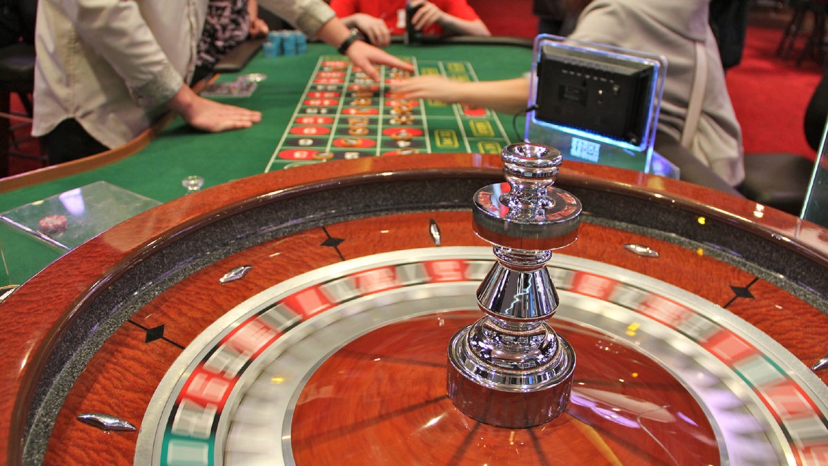 Patrons lay their bets as the wheel turns at SugarHouse Casino in Philadelphia. (Emma Lee/WHYY, file) 
