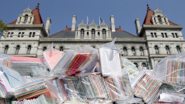  This May 21, 2013, image shows some of the 400,000 signed postcards to be delivered to N.Y. Assembly members, calling on them to repeal the NY SAFE Act, stacked on a table outside the Capitol during a Second Amendment rally. (AP Photo/Mike Groll, file) 
