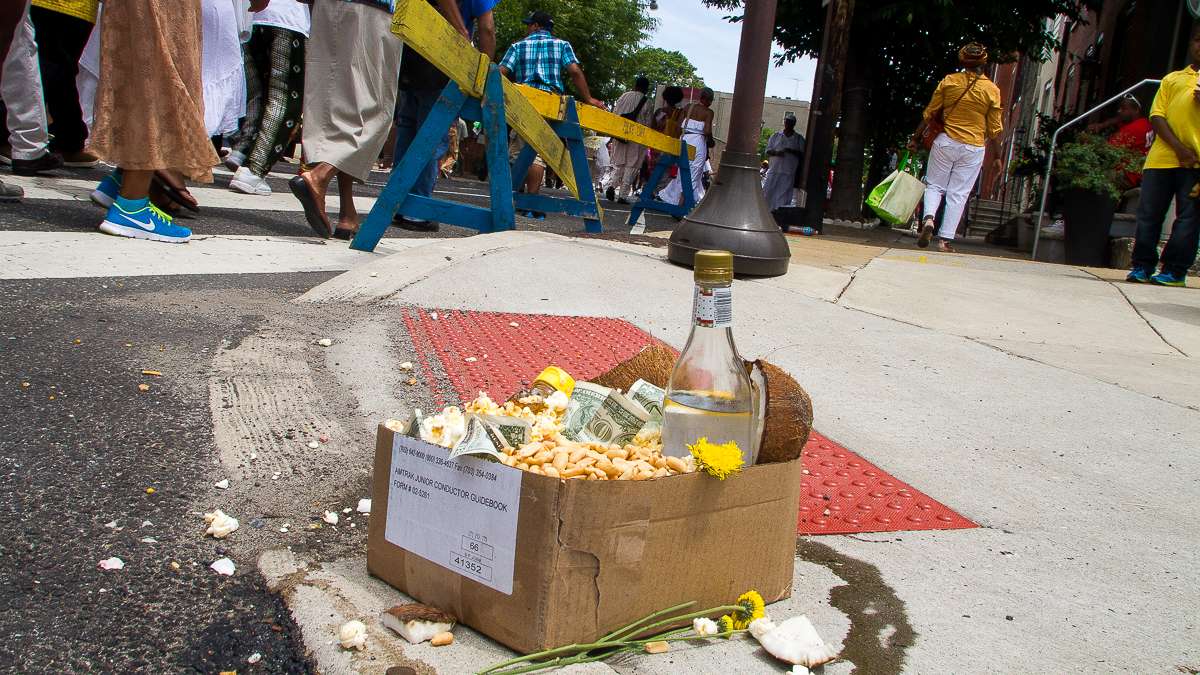 Offerings of popcorn, peanuts, honey and other foods accumulate on the corner of 27th and South streets during the Odunde Festival. (Brad Larrison/for NewsWorks)