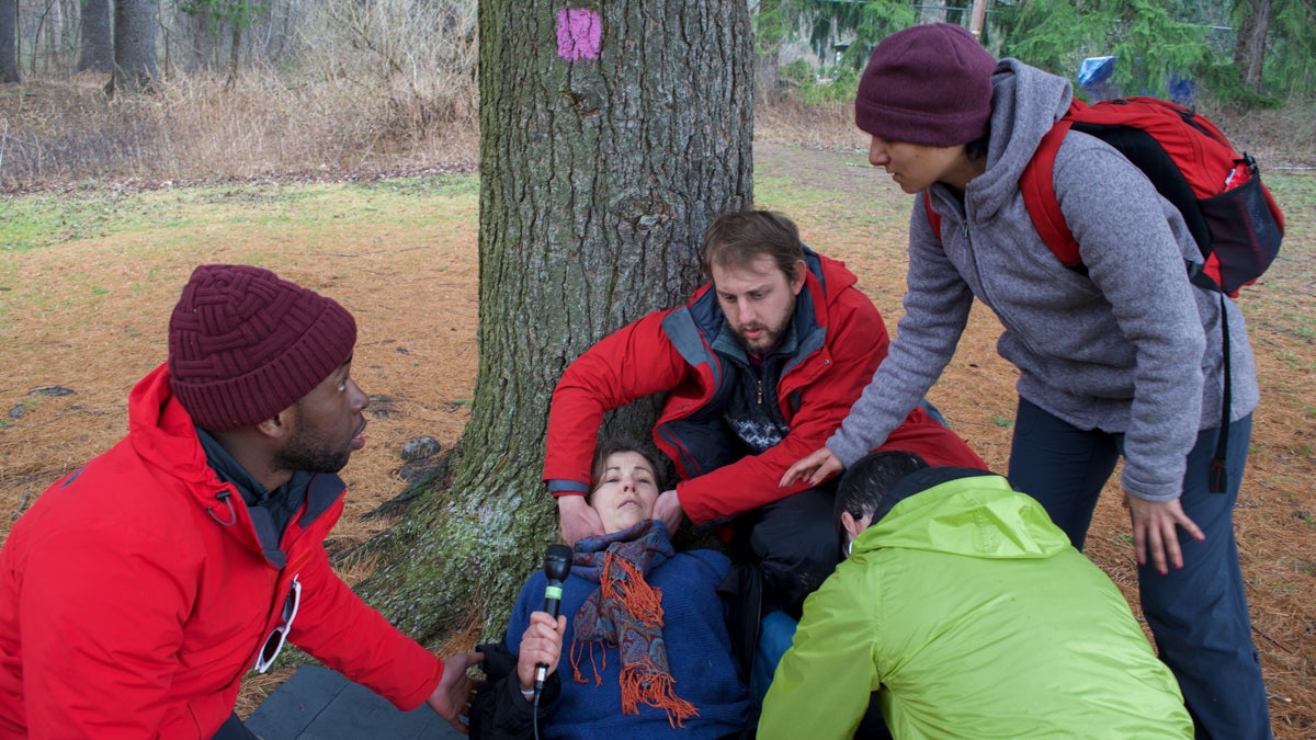  Maiken Scott pretends to be a birder who fell from a tree, while students from the School of Medicine at the University of Pennsylvania examine her. (Paige Pfleger/WHYY) 