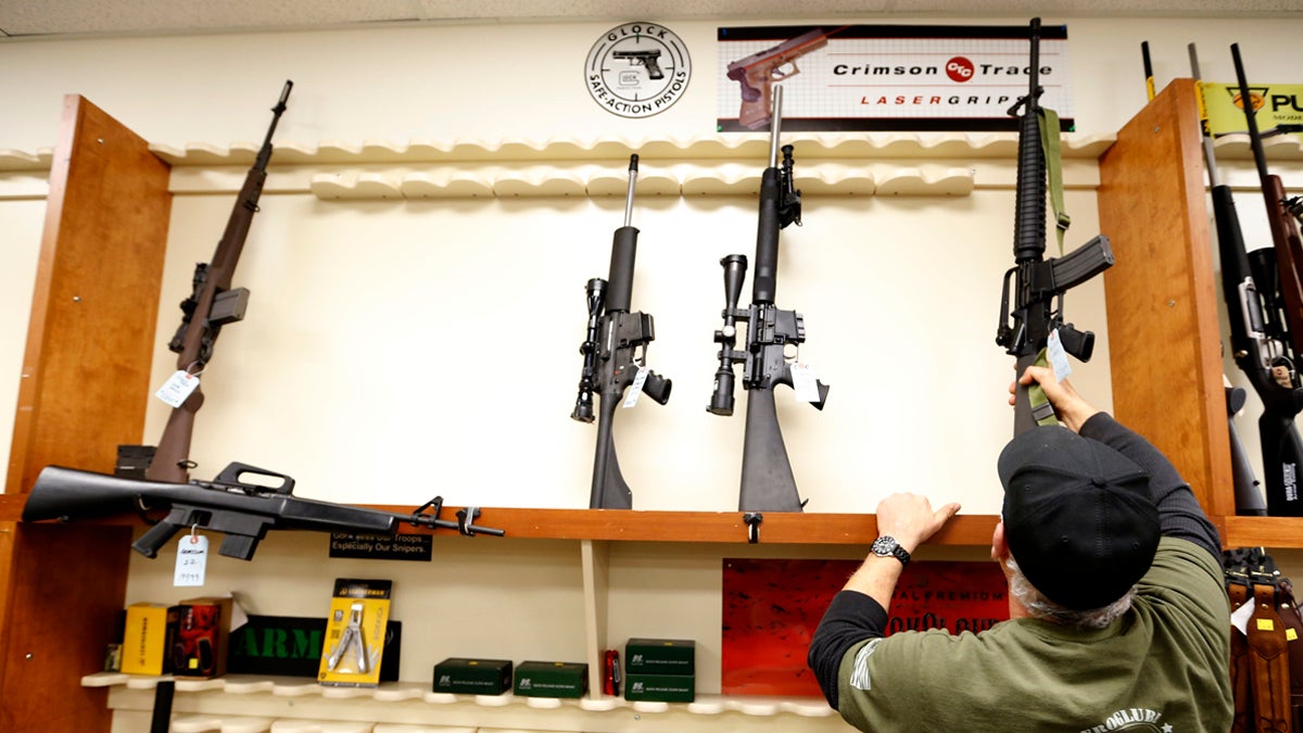  In this file photo, a store manager replaces one of the five used military style rifles onto a rack that usually has more than 20 models for sale in in New Castle, Pa.  (AP Photo/Keith Srakocic) 