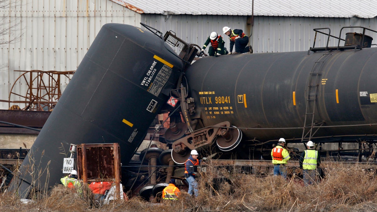  In this Friday, Nov. 30, 2012 file photograph, officials examine a derailed freight train tank car in Paulsboro, N.J., after a train derailed and several tanker cars carrying hazardous materials toppled from a bridge and into a creek. (Mel Evans/AP Photo, file) 