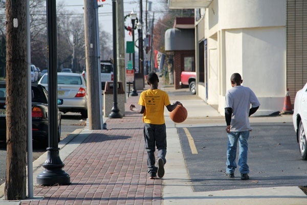 <p>DeAndre Gardner and William Graham head out to play basketball on Broad Street in Paulsboro. Because of a chemical spill, residents were warned to stay indoors and schools were closed, but by noon the warning had been lifted. (Emma Lee/for NewsWorks)</p>
