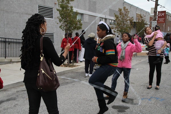 A group of teens plays double dutch jumprope.