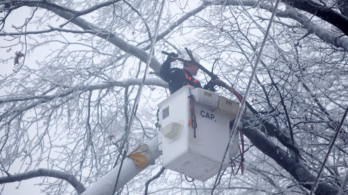  In this February 2011 photo, a PECO worker removes ice covered branches near lines in a neighborhood without power in Coatesville, Pa. (Matt Rourke/AP Photo, file) 