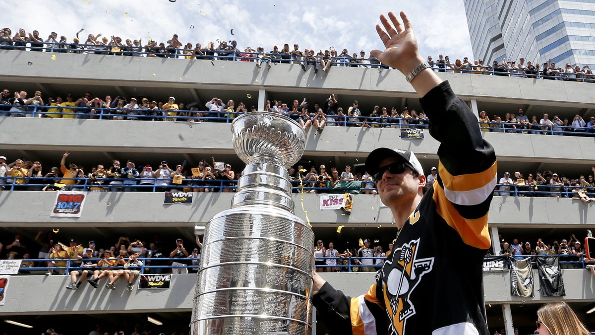  Pittsburgh Penguins' Sidney Crosby waves to the crowd while holding onto the Stanley Cup while riding along the victory parade route in Pittsburgh, Pa., Wednesday, June 15, 2016. The Penguins defeated the San Jose Sharks on Sunday, June 12 to win the NHL hockey championship. (AP Photo/Keith Srakocic) 