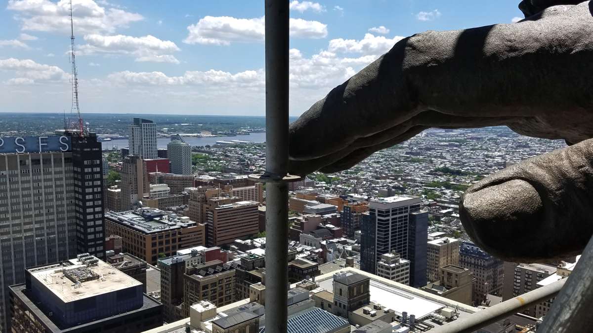 The hand of William Penn hovers above Philadelphia, a view made possible by scaffolding that has been erected to clean and repair the statue atop City Hall. (Peter Crimmins/WHYY)
