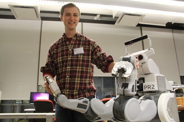 <p>Penn student Ian McMahon manipulates a PR2 robot, sometimes used in assembly line work. (Emma Lee/for NewsWorks)</p>

