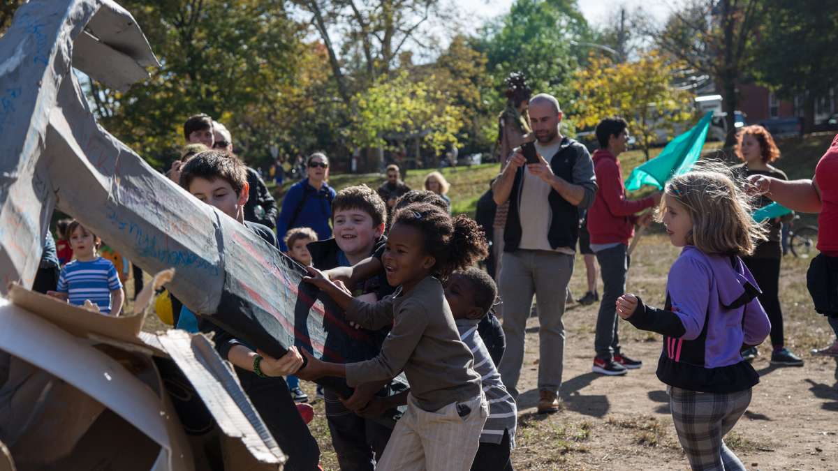 Children use a paper maché hammer to smash the boulder of injustice at the conclusion of the 17th annual Peoplehood parade Oct. 29, 2016. (Emily Cohen for NewsWorks)