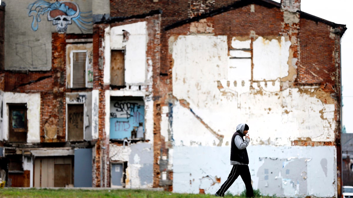  A man walks through a vacant lot where the impression on a demolished home remains on a standing building in the Northern Liberties neighborhood of Philadelphia. (AP Photo/Matt Rourke) 