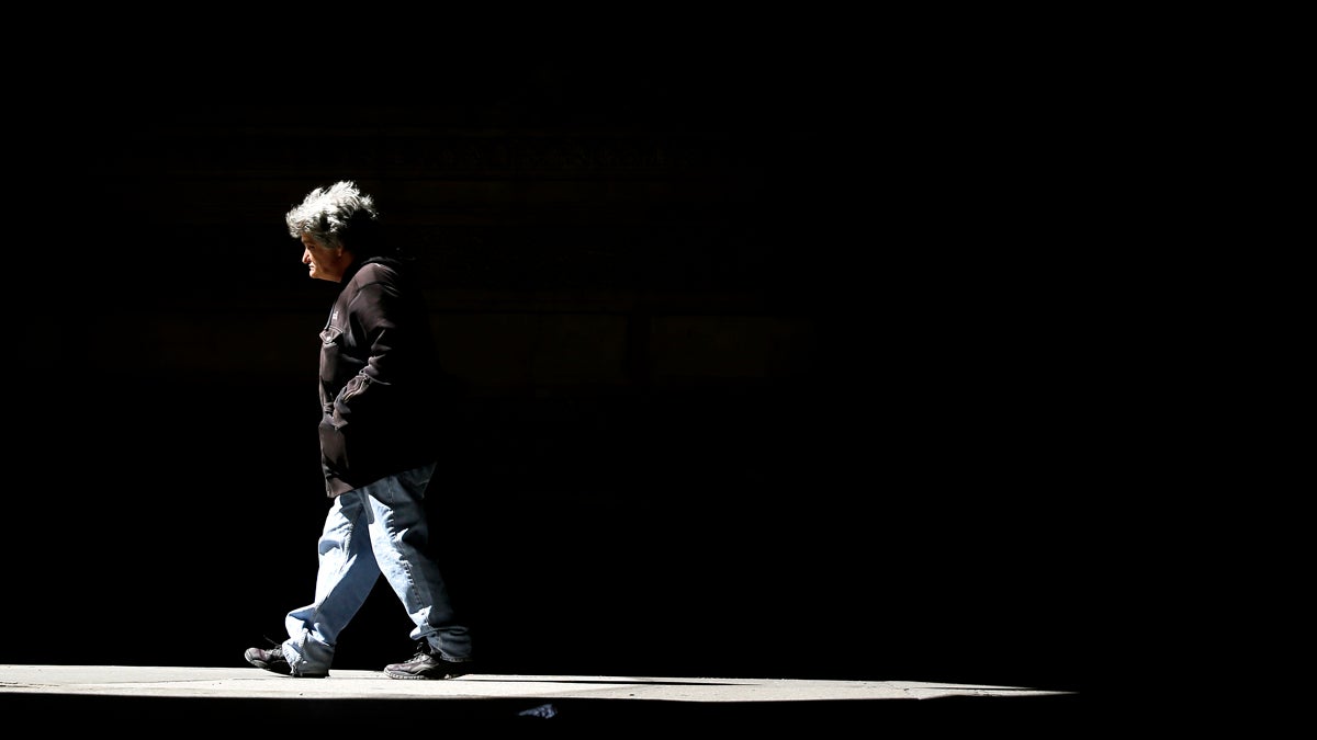  A pedestrian passes into the light from beneath City Hall in Philadelphia, Pa.. (AP Photo/Matt Rourke) 