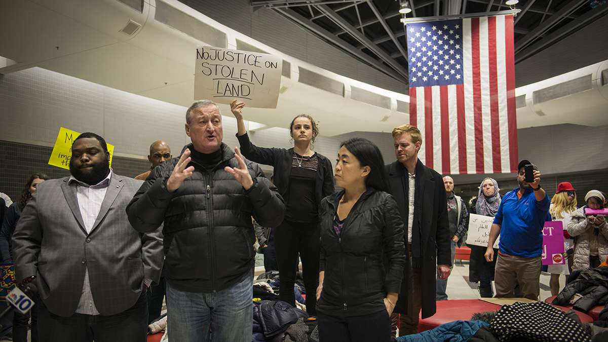 (From left) Rep. Jordan Harris, Philadelphia Mayor Jim Kenney, and Councilwoman Helen Gym speak to protesters and media about the developing situation regarding President Donald Trump’s executive order on immigration at the Philadelphia International Airport. (Branden Eastwood for NewsWorks)